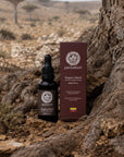 Dragon's Blood bottle and box at the base of a tree