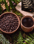 Bowl of roasted Witoca Shaman coffee beans and a cup of black coffee