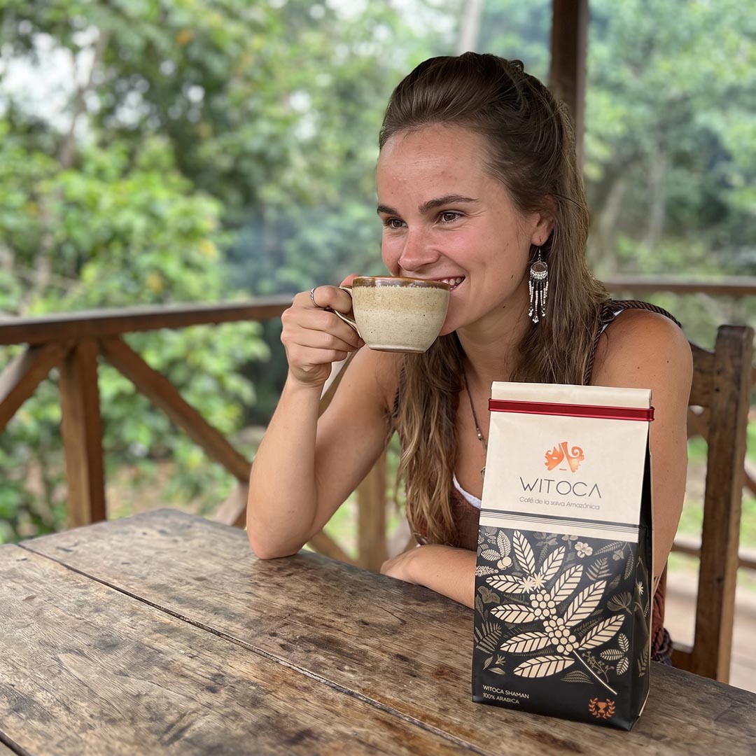 Woman drinking Witoca Shaman coffee at a wooden table