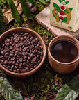 Bowl of roasted Witoca Sumak coffee beans and a cup of black coffee beside the bag