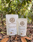250g and 125g bags of Ceremonial Cacao Drops in a cacao plantation