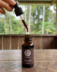 Dropper releasing Dragon's Blood resin into the 30ml bottle
