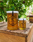 200ml and 30ml jars of HASA stingless bee honey on a wooden hive