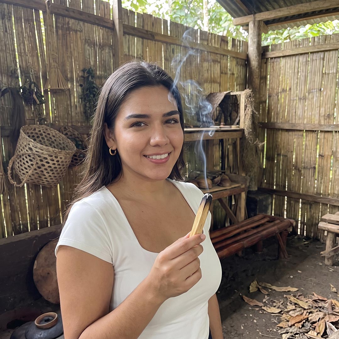 Woman holding a smoking stick of Palo Santo
